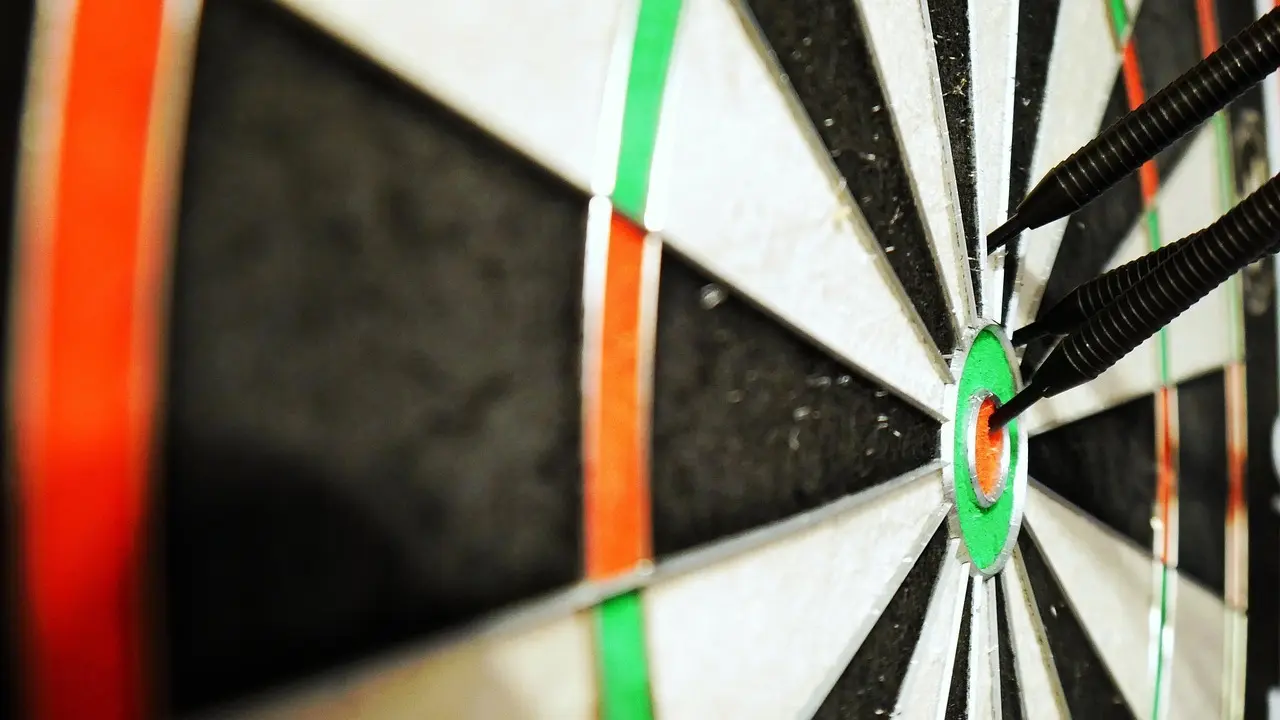 Dartskive med tre pile i bullseye
