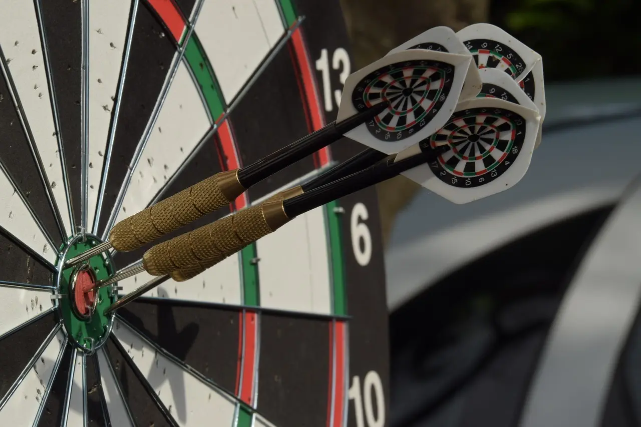 Dartskive med tre pile i bullseye