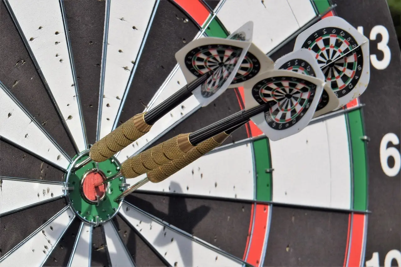 Tre dartpile i bullseye på en dartskive
